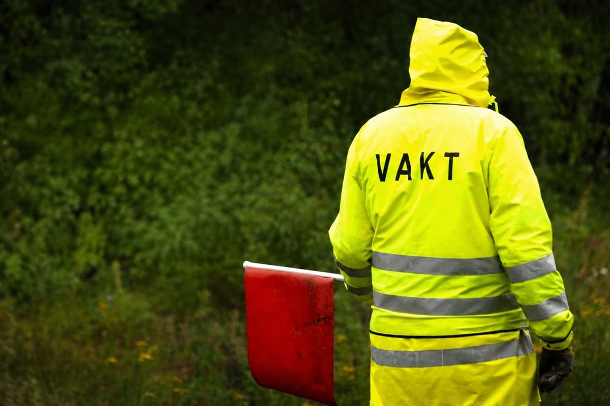 Flaggvakt som dirigerar trafiken vid ett vägarbete i Umeå
